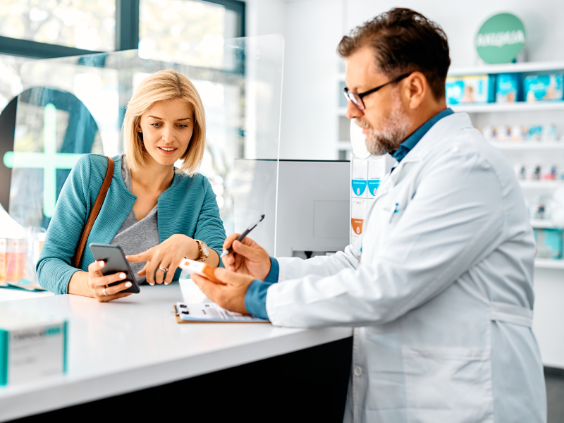 A doctor is holding two phones while talking to another person.