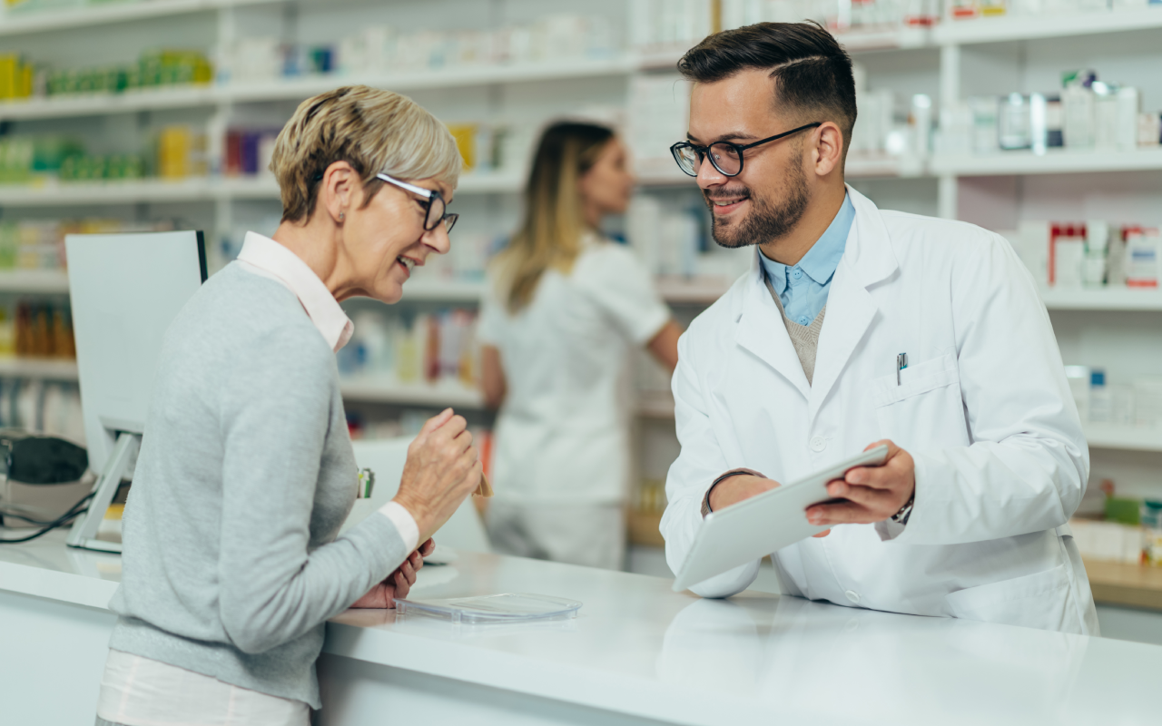 A man and woman talking to each other in a pharmacy.