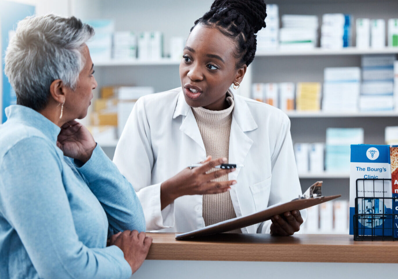 A woman talking to a pharmacist in front of her.